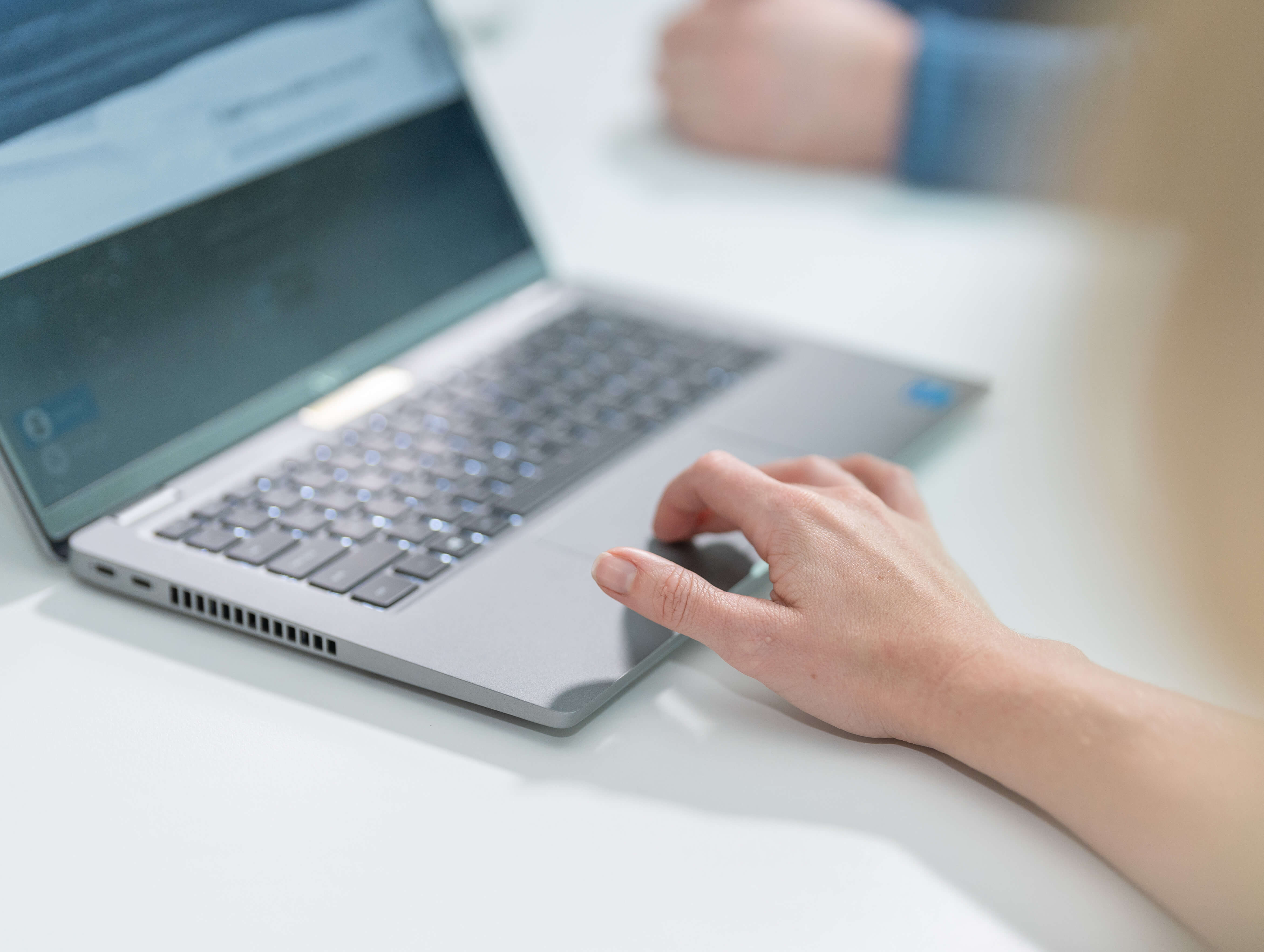 Image of laptop with employee's hand