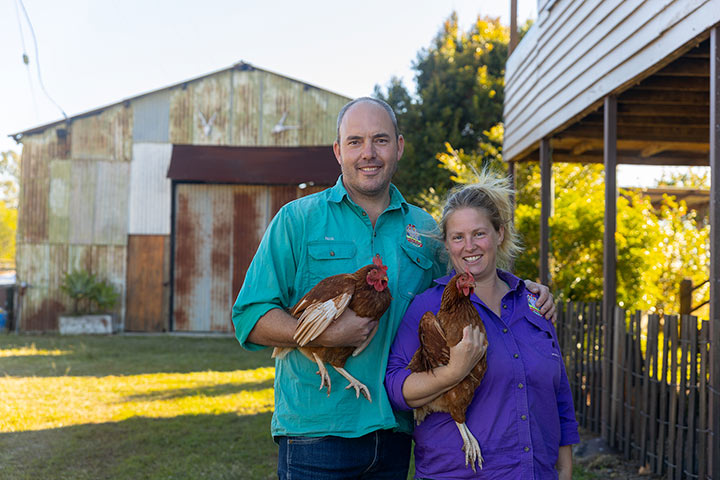 Nick and Amanda Kuhn stand holding their chickens.