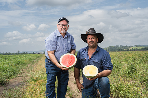 Sam Spina stnads next to Mat Di Mauro holding a red and yellow watermelon