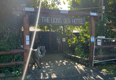 A sign outside a pub reads 'Lions Den Hotel'